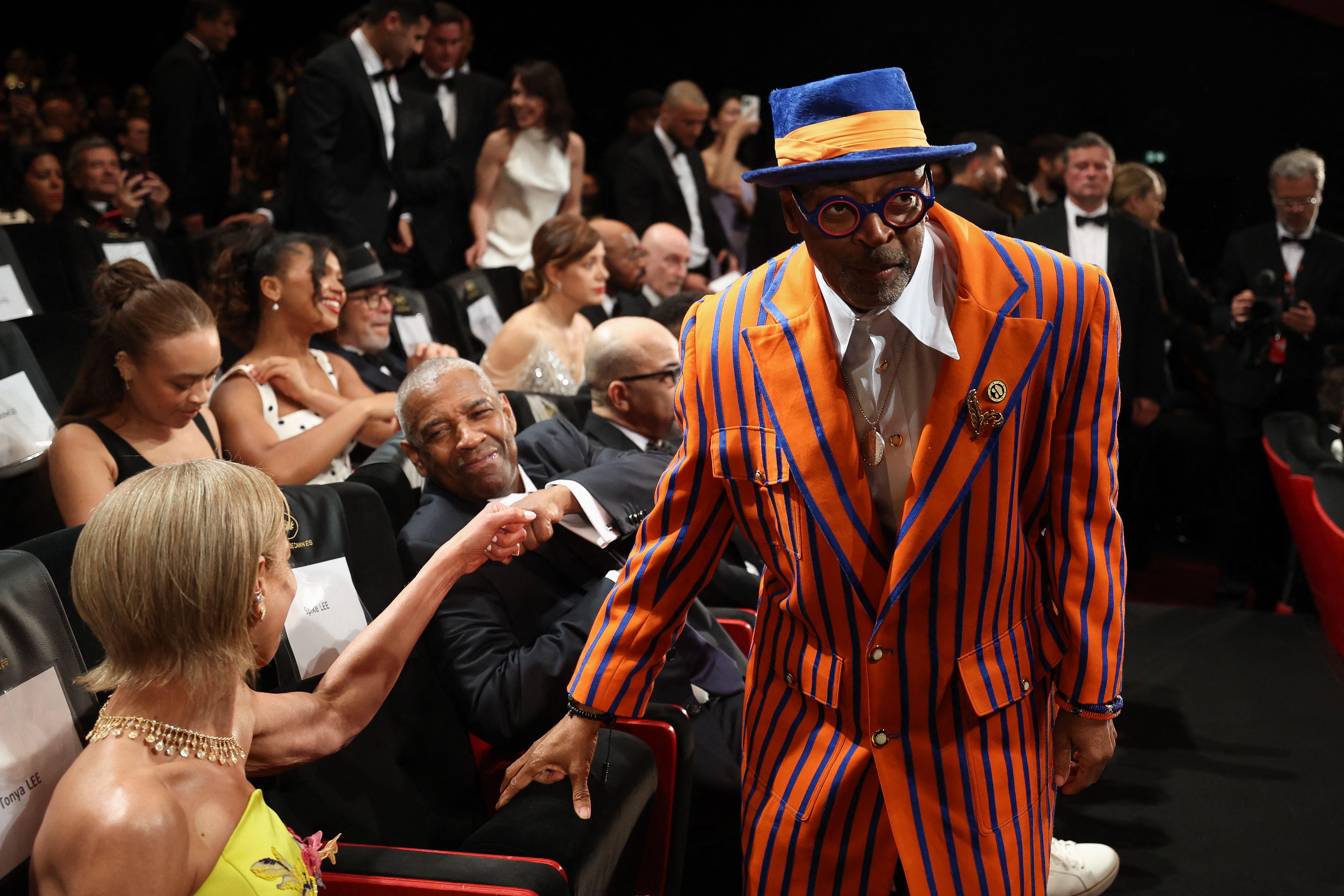Denzel Washington shook hands with US producer Tonya Lewis Lee before receiving the Honorary Palme d'Or from US director and executive producer Spike Lee, ahead of the screening of the film Highest 2 Lowest at Cannes 2025