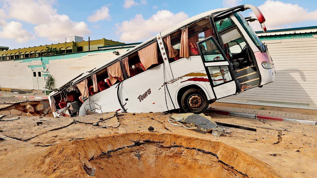 A bus that fell inside a crater following an Israeli strike in Khan Yunis