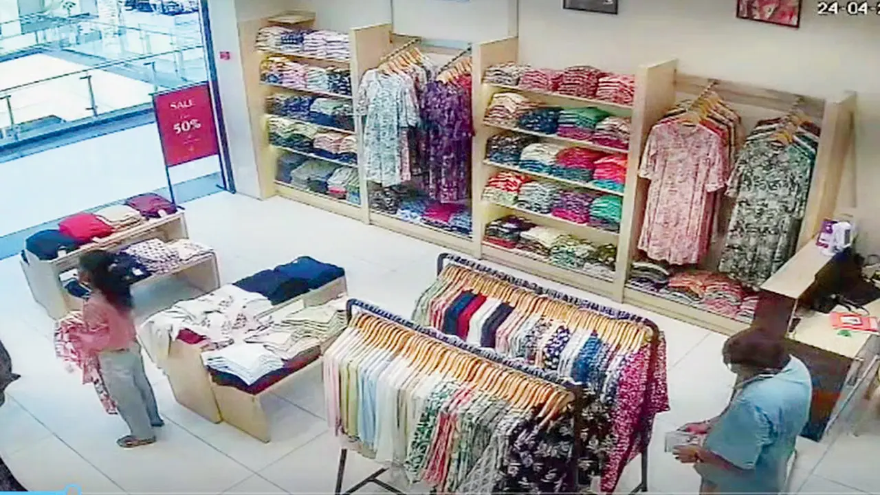 A video grab of Milan checking the cash he stole from the counter. PICS/BY SPECIAL ARRANGEMENT