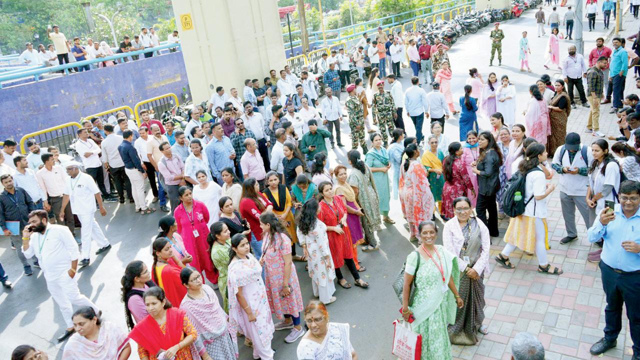 Evacuated people wait outside the Pimpri-Chinchwad Municipal Corporation building