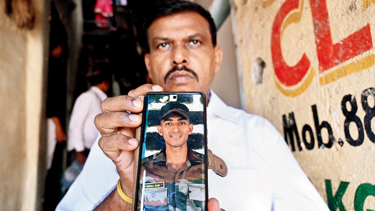 Ranga Naik, a relative, shows an image of Murli Naik