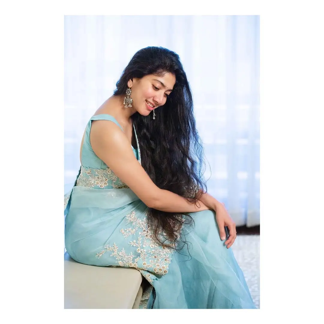 In this look, Sai wore a white saree that featured a broad border and a sheer pallu. She left her long hair open without tying it into any hairstyle and yet again stole hearts with her charm