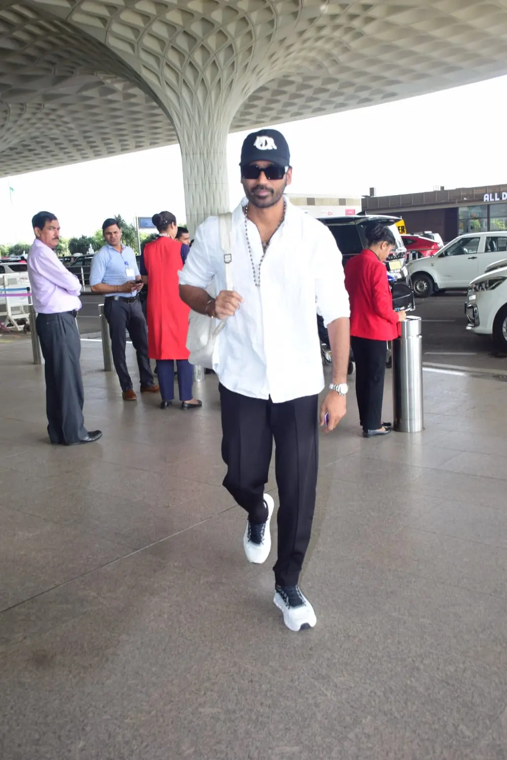 Dhanush stole the show at AR Rahman's concert at DY Patil Stadium yesterday, and now the actor decided to make hearts beat faster with his stylish airport look. He aced his appearance in a white shirt and black jeans