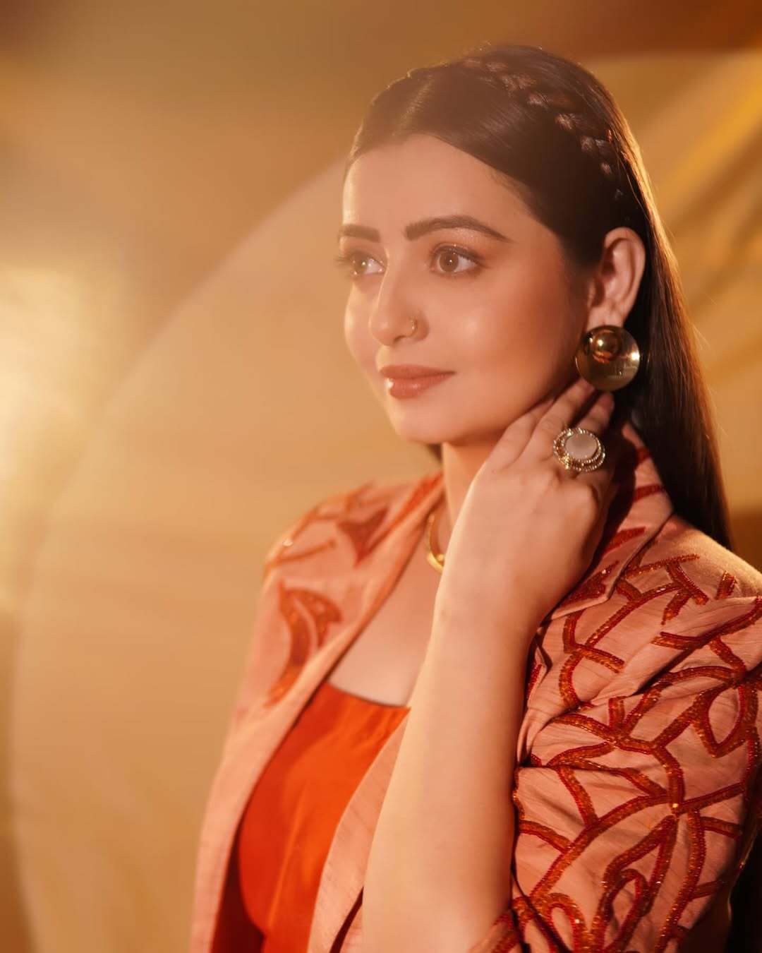 In this look, the actress kept her makeup minimal with a hint of shiny blush and light eyeshadow. She accessorized with a stacked bracelet, a choker, and beautiful big studs
