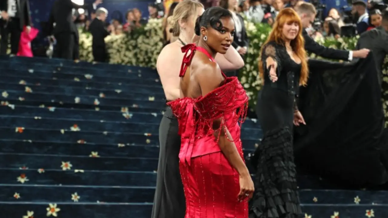 Olympic gold medalist Gabby Thomas brought bold color to the carpet in a fiery red look with off-the-shoulder sleeves