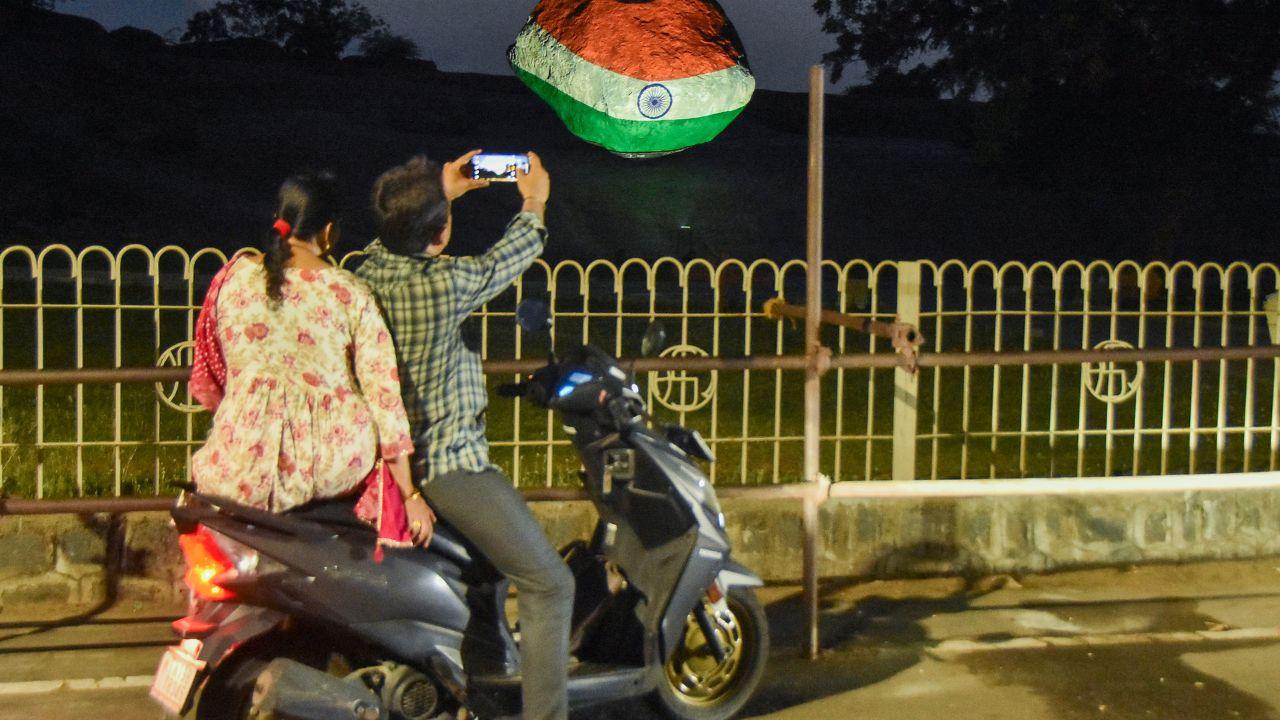 A commuter captures the majestic Krishna's Butterball bathed in tricolour lights in Mamallapuram, Tamil Nadu