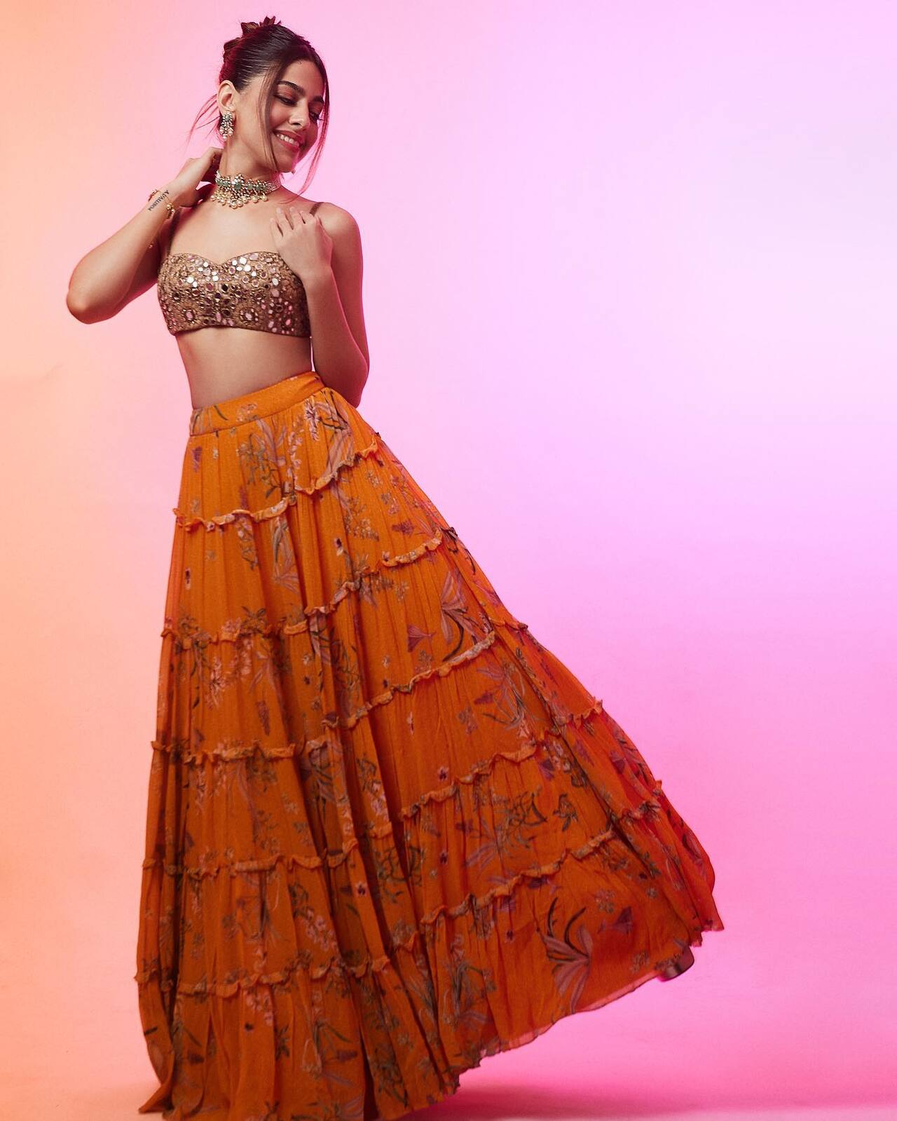 Orange brings a rush of vibrancy and energy, and Alaya F reflects it in a frilled chaniya choli with mirror work on the blouse. The actress shows how to make an ultra-glam choice for festive season!