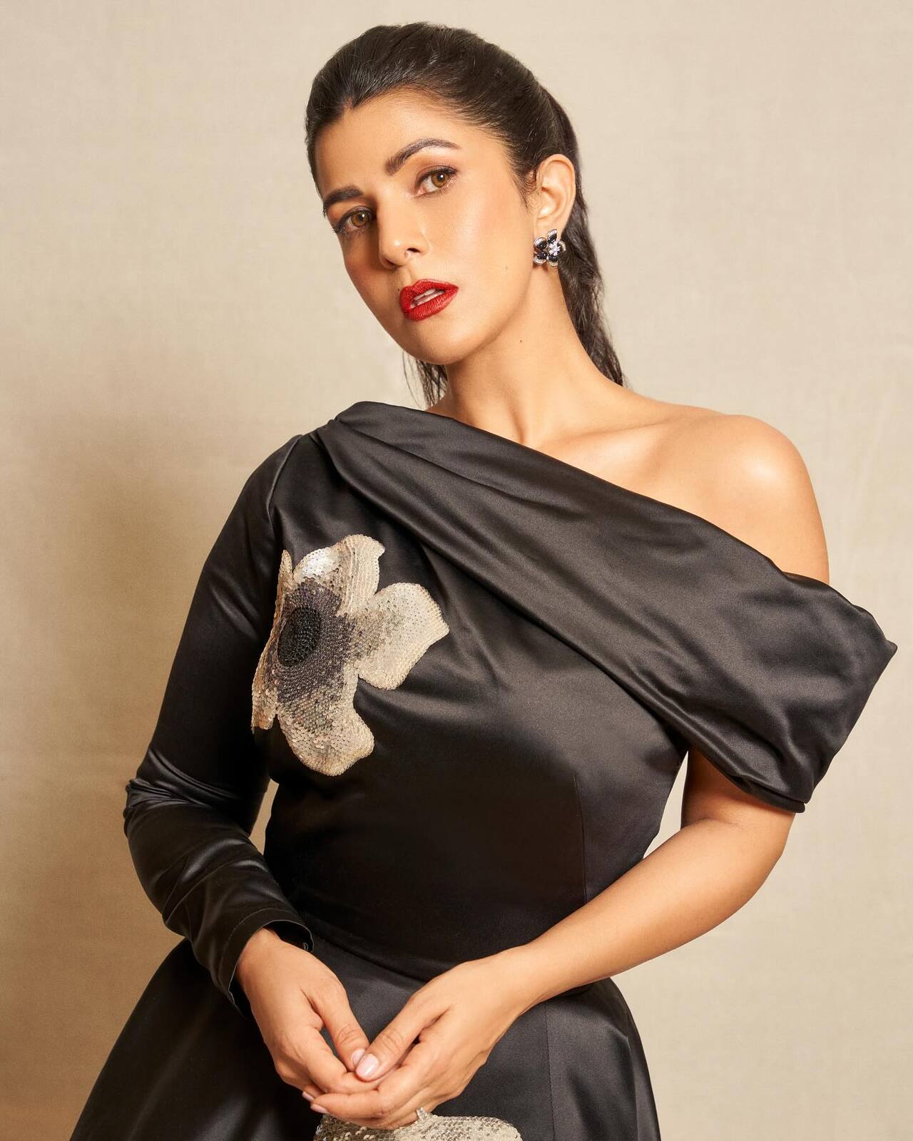 She looks gorgeous in a black ballgown with a huge silver flower printed on the skirt. Nimrat's makeup added a much-needed dose of glam to her look. She styled her hair in a sleek poytail and a pair of silver flower earrings.