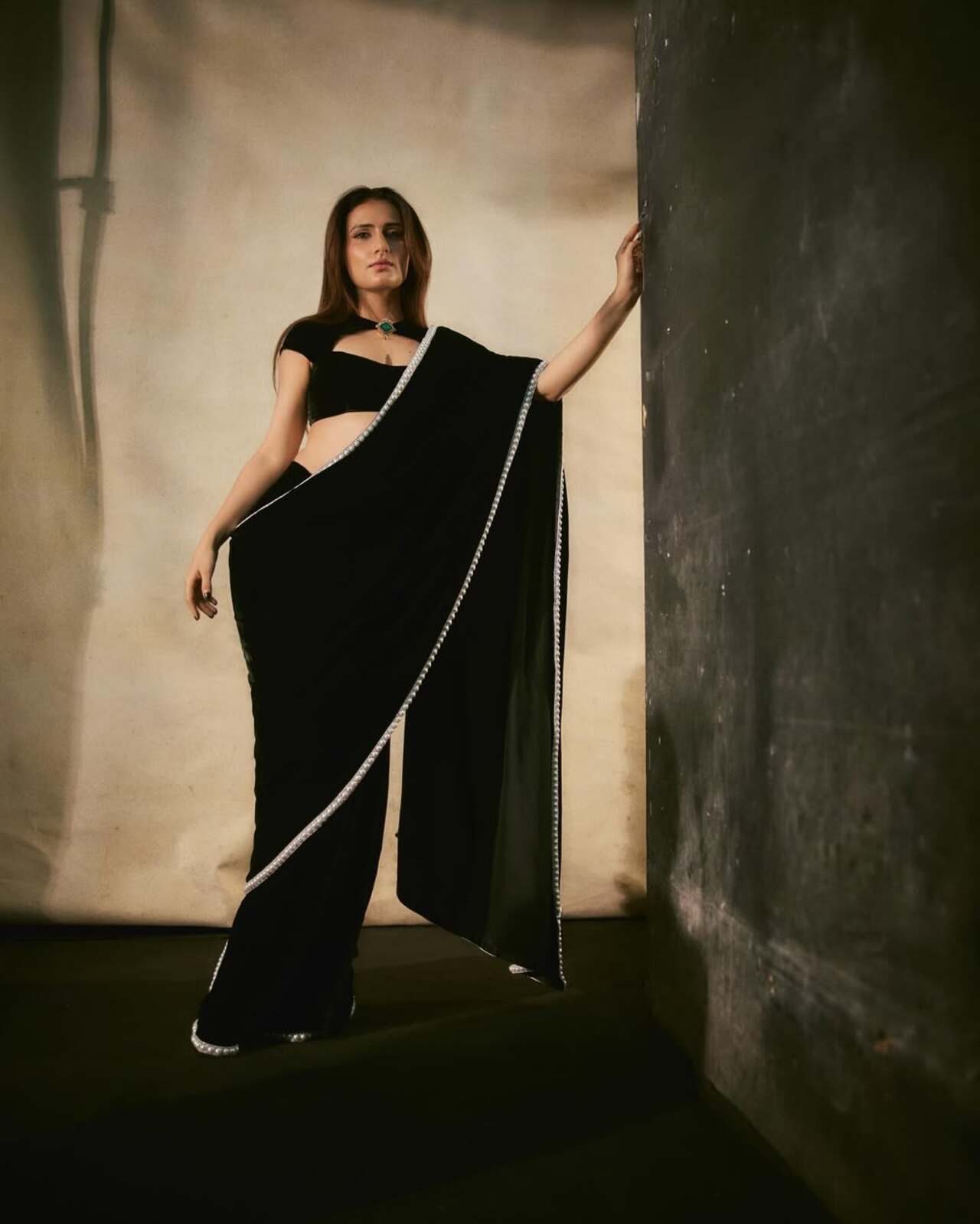 If elegance ever came with a winter upgrade, it would be Fatima Sana Shaikh in a black velvet saree paired with a striking cut-out blouse and a single bold emerald pendant stealing the spotlight.