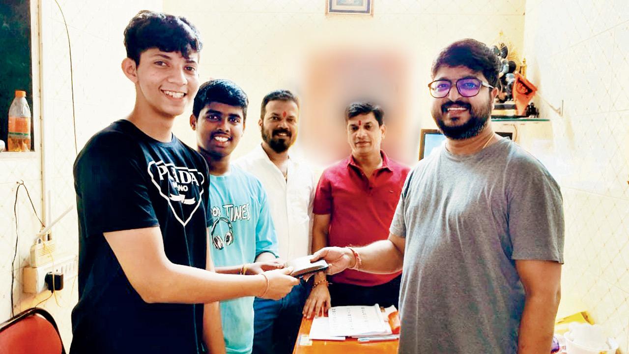 (From left) Parth Nandvikar, Rugved Jadhav, and Ravindra Jadhav hand over the wallet to Shekhar Harad. PICS COURTESY/RAVINDRA JADHAV