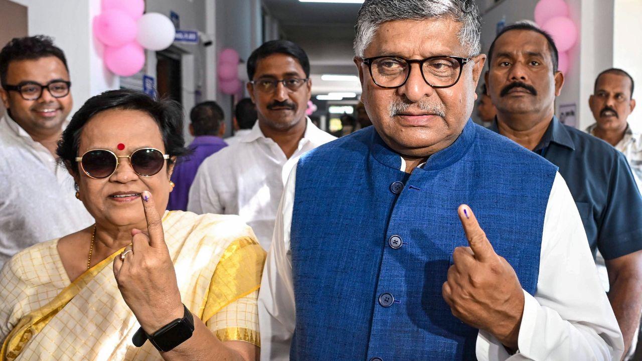 BJP MP Ravi Shankar Prasad and his wife display their inked fingers after casting their votes at a polling station during the first phase of the Bihar Assembly elections in Patna