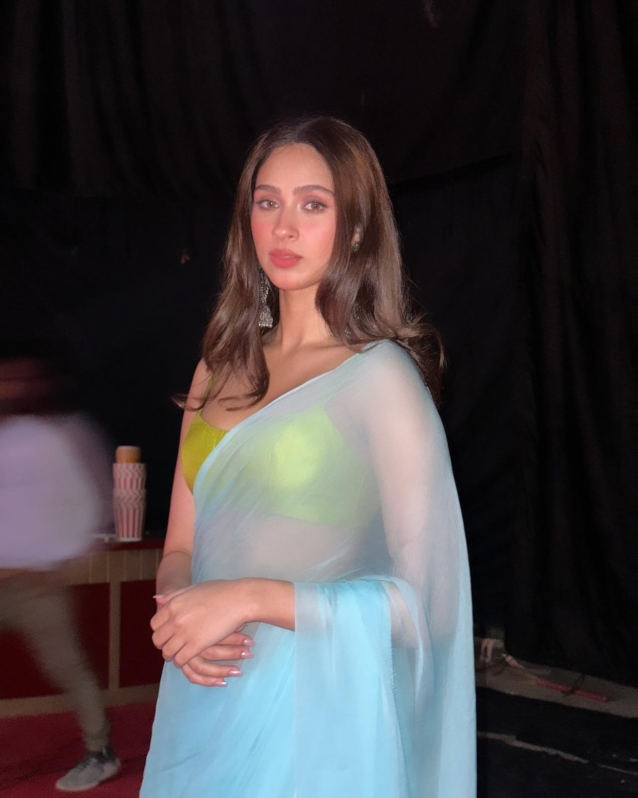 Enjoying her chiffon saree moment, Pashmina mesmerises in this blue see-through saree paired with a neon green blouse. She keeps it simple yet elegant with statement earrings and her natural makeup. 