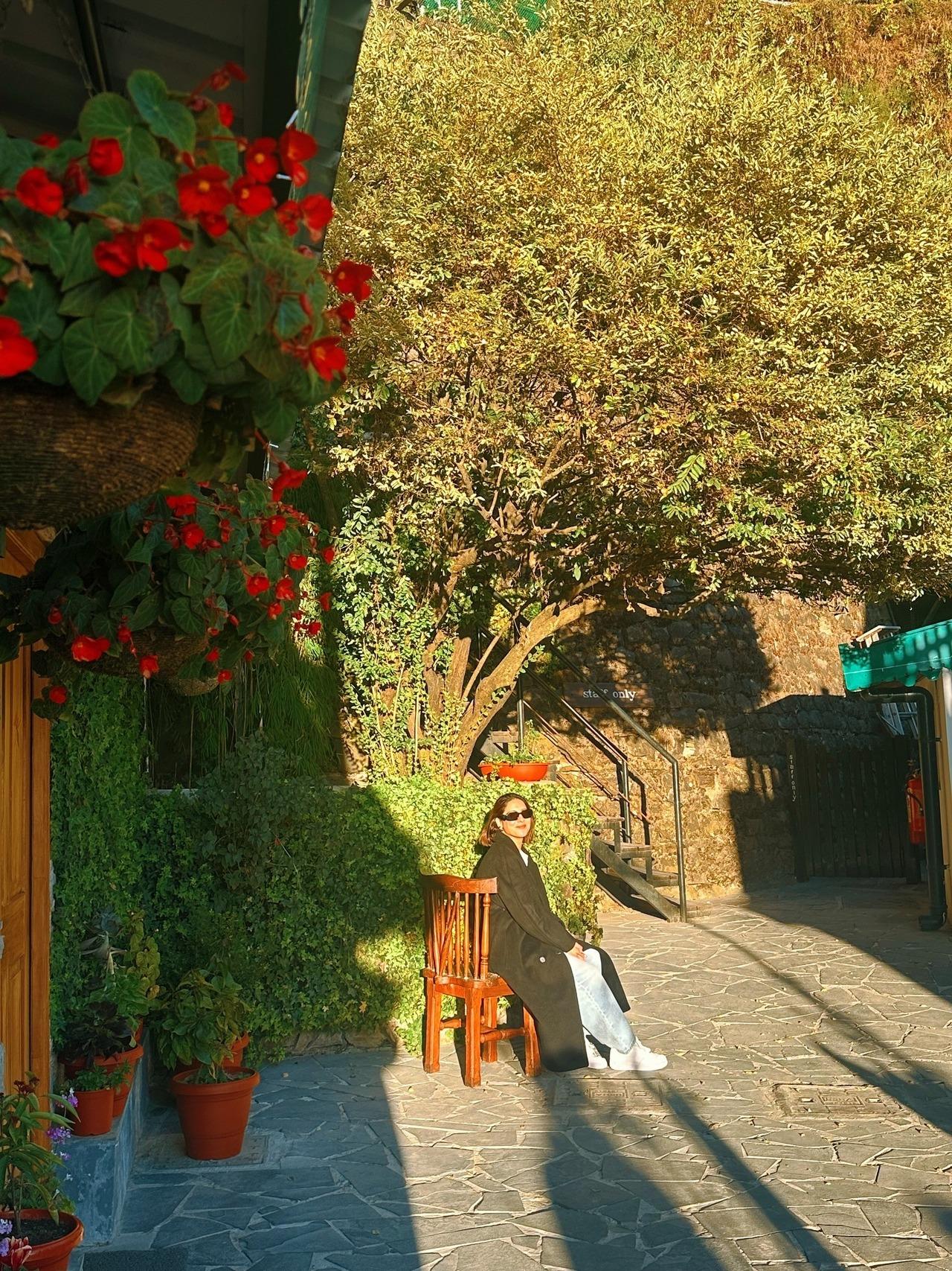 <p>Sheetal soaks in the warmth of the sun in the hills surrounded by lush trees and colourful flowers in this picture.</p>