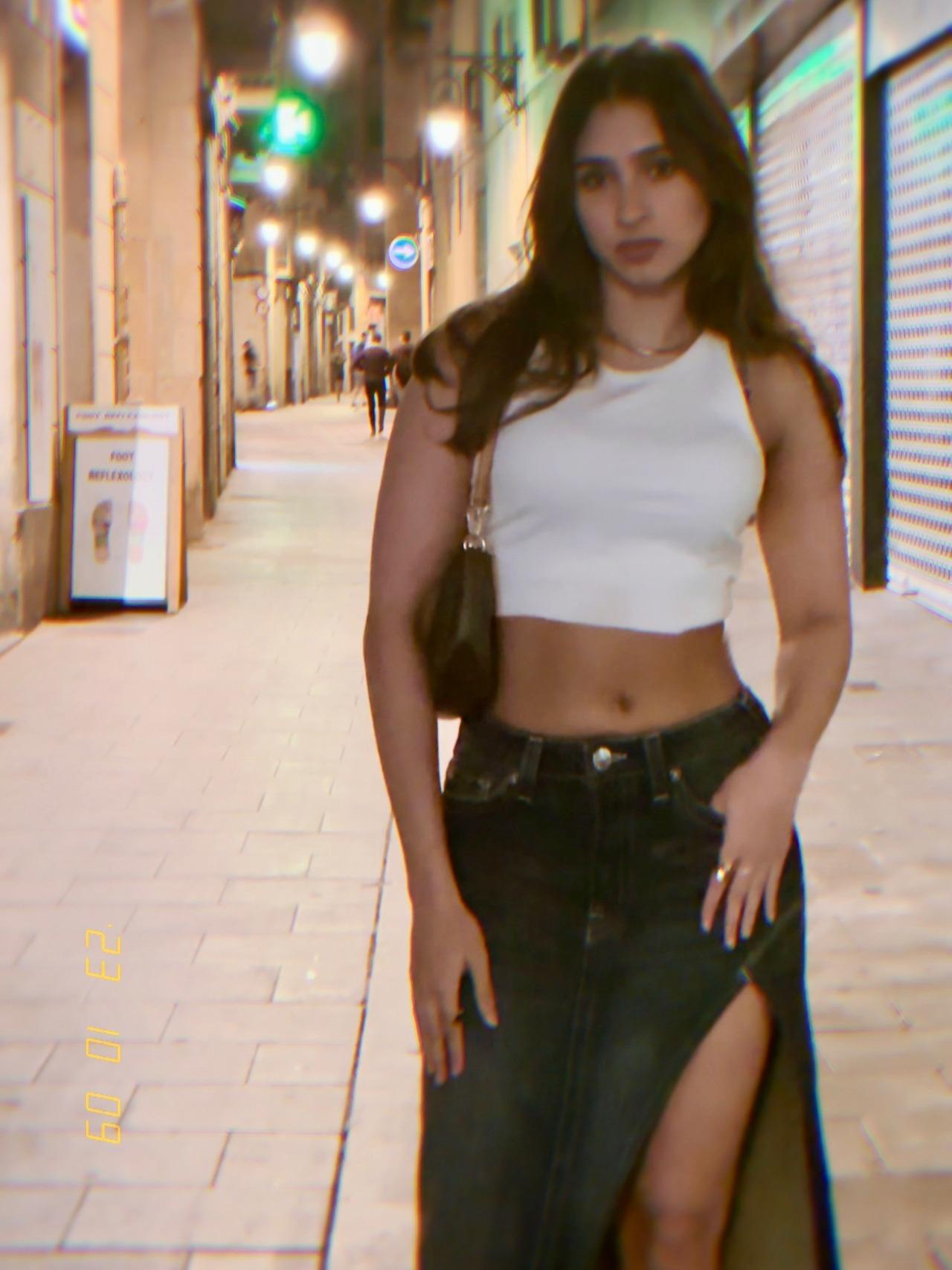 Casual and chic, Pashmina keeps it simple in a white crop top paired with a high-slit denim skirt. With no jewellery or elaborate accessories, Pashmina carries a black bag to complete the look.