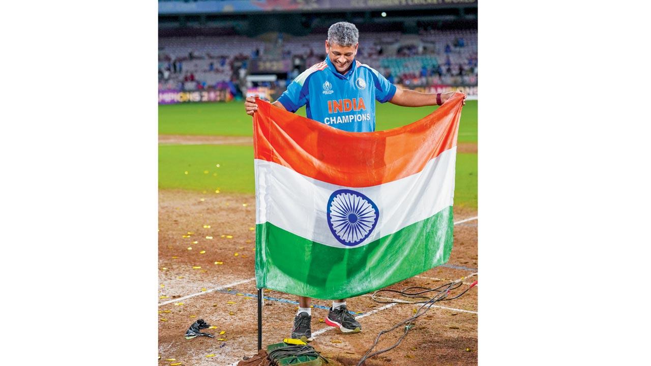 India coach Amol Muzumdar plants the tricolour on the DY Patil Stadium pitch after the team won the Women’s World Cup. Pic/PTI