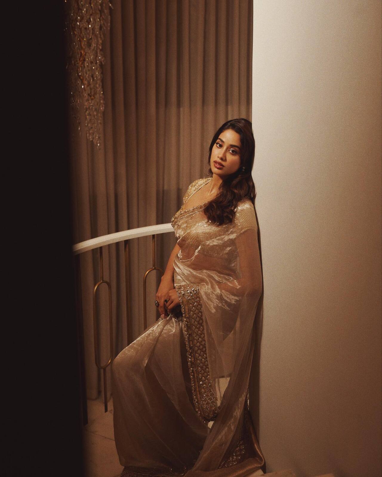 Want to take the centre stage at wedding functions? This look of Janhvi Kapoor can create that magic. She made a statement in a golden tissue saree featuring an intricately detailed border and blouse. She kept her accessories minimal with drop earrings and a few rings.