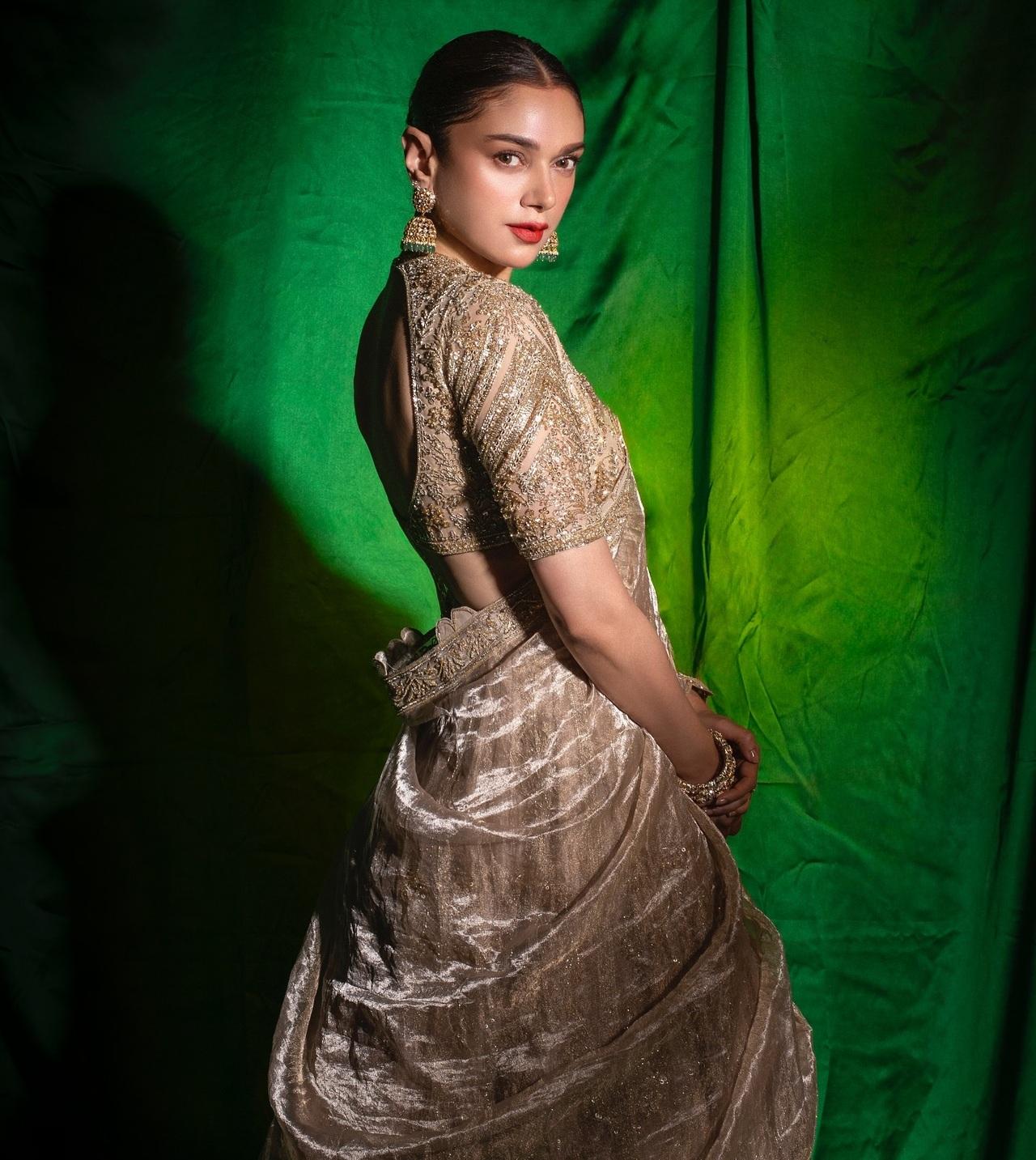 Aditi kept it regal by donning a heavily worked-up golden lehenga featuring zari work all across. The elbow-length sleeves and a V-neckline added structure to the full appearance, and the tissue dupatta amped up the outfit’s royal feel. 