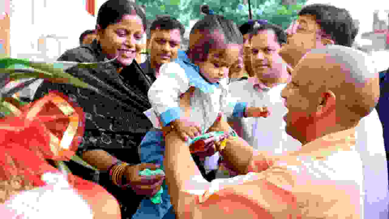 Uttar Pradesh Chief Minister Yogi Adityanath interacts with a child while distributing gifts in Ayodhya