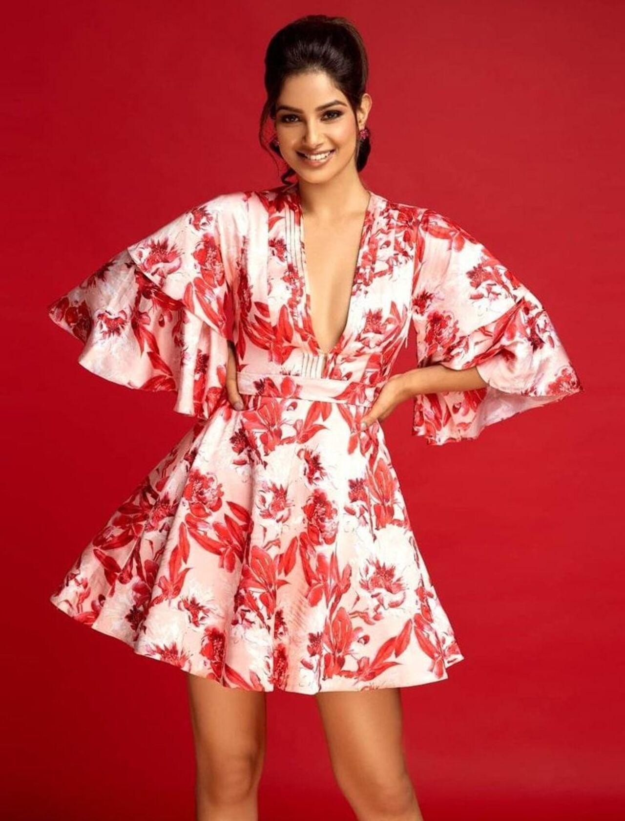 Casual and chic, Harnaaz looks cute and elegant in this easy-breezy white and red floral mini-dress. 