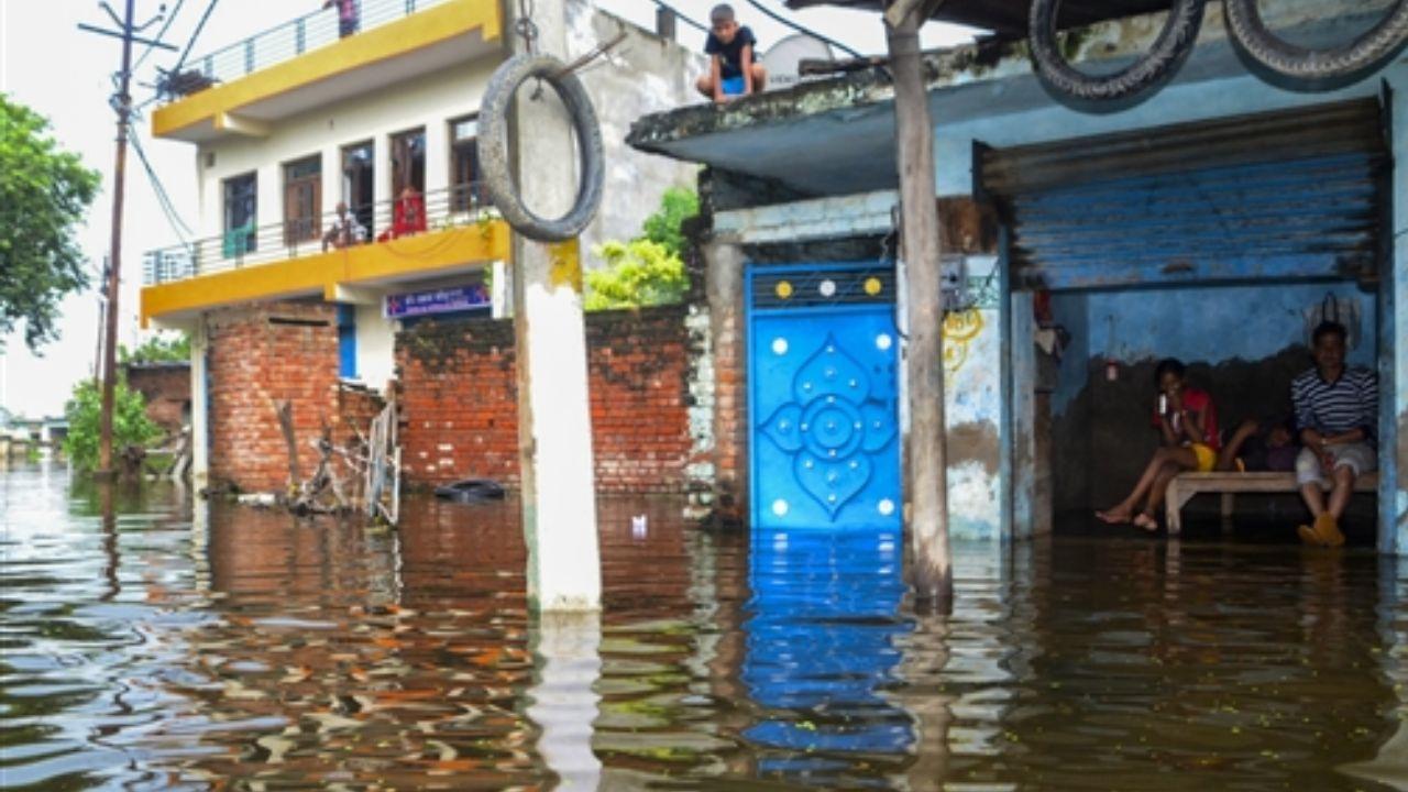 Residents observe floodwater from the swollen Ganga river inundating parts of Kanpur district in Uttar Pradesh