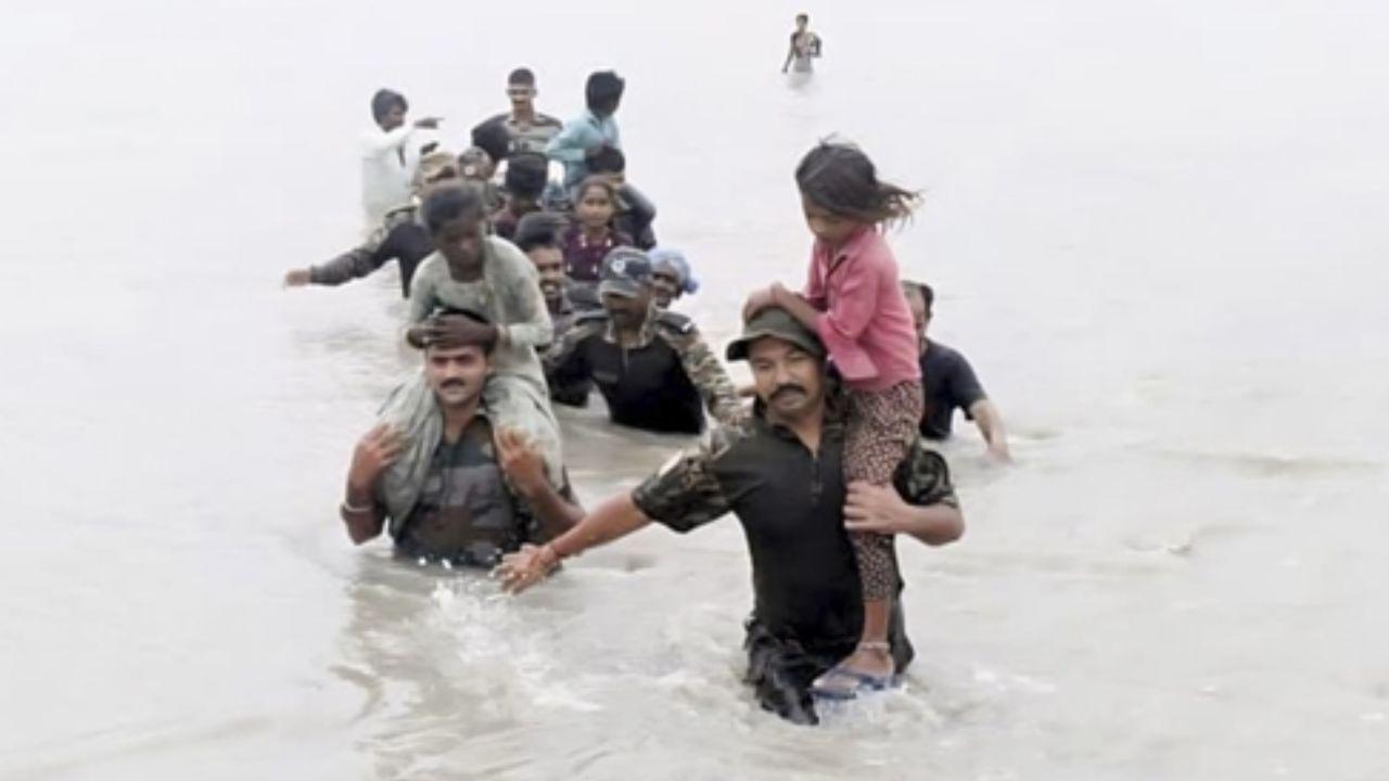 Indian Army's Golden Katar Division personnel, part of the Konark Corps,, evacuate stranded people during a rescue operation in a flood-affected area after heavy rainfall in Barmer district of Rajasthan