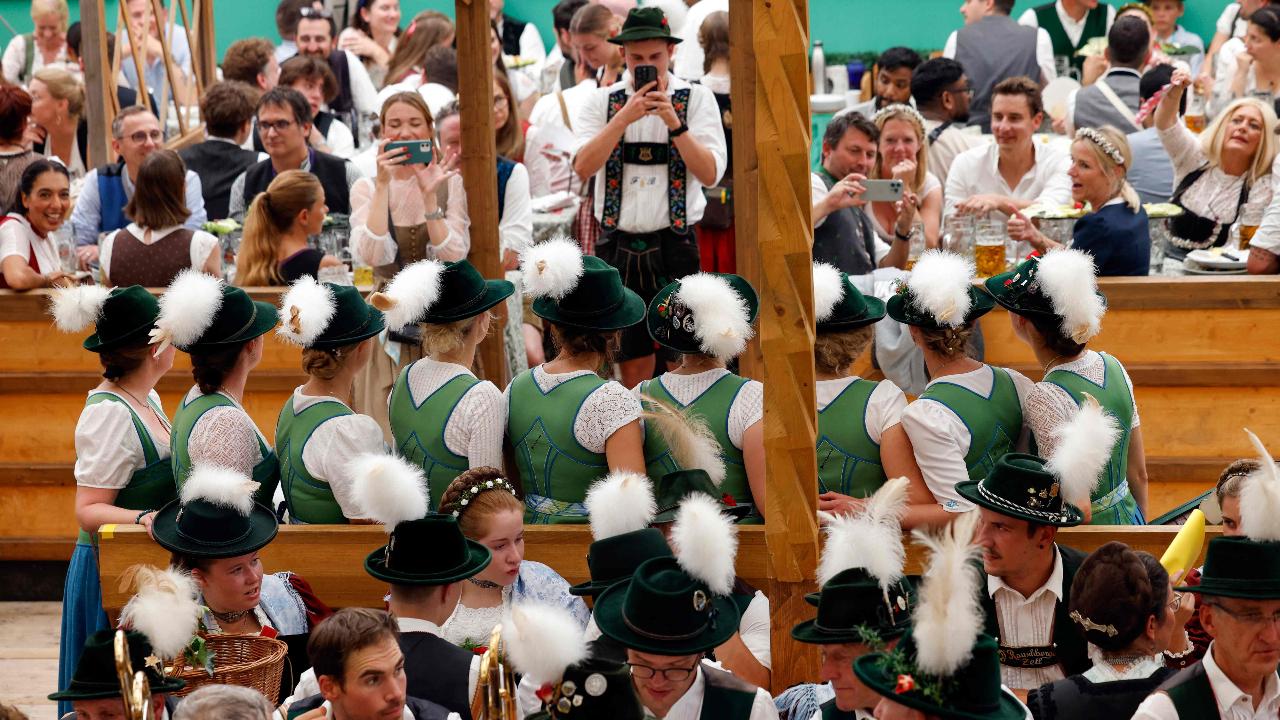A group of visitors wearing traditional clothes, clicking group photos. Photos Courtesy: AFP