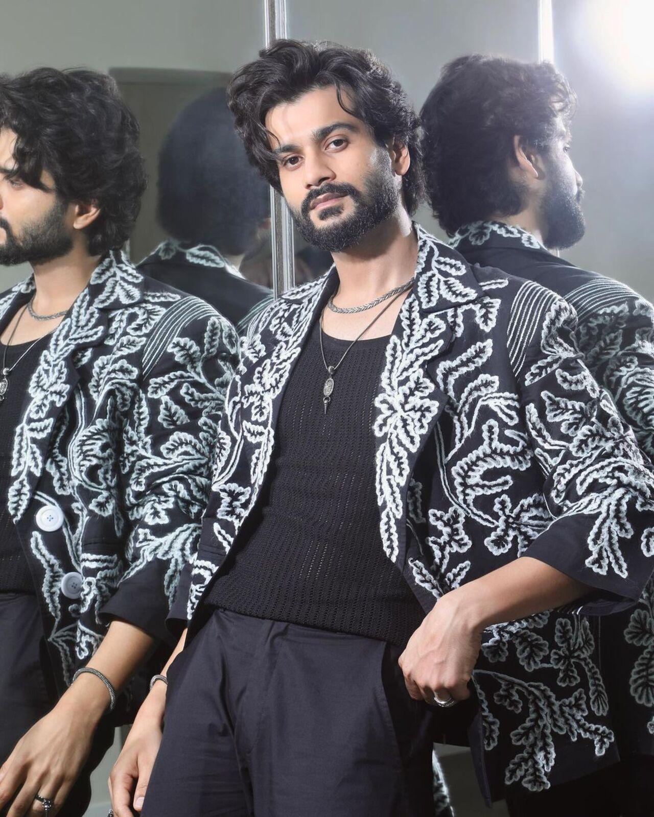 Bringing in the funk, Sunny dons this black and white doodle printed jacket while maininting balance with a pain black shirt and a silver chain.