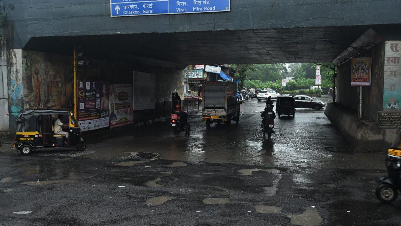 Despite the difficult conditions, both vehicular traffic and pedestrians continued to move cautiously through the waterlogged stretch