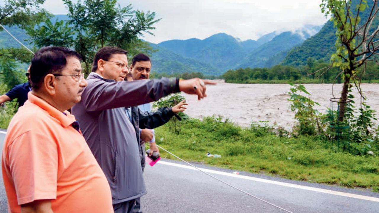 Uttarakhand CM Pushkar Singh Dhami (in grey) inspects disaster-affected areas. PIC/PTI