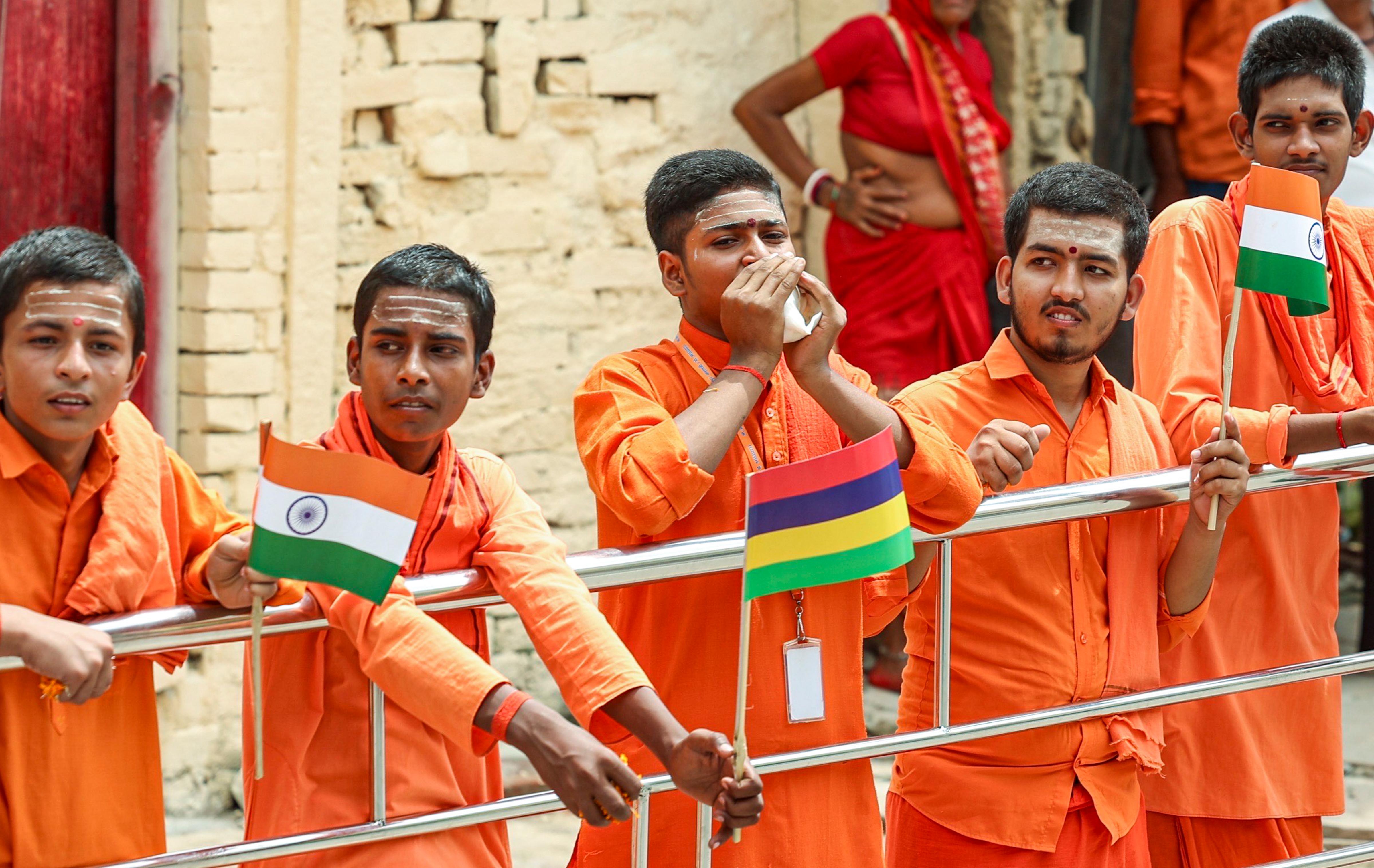  People hold the national flag during Prime Minister Narendra Modi's (unseen) roadshow, in Varanasi