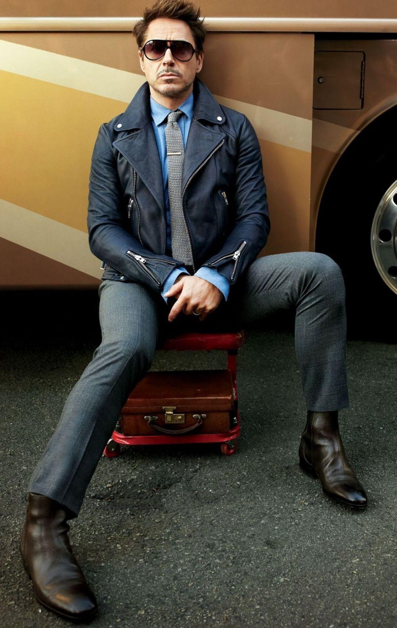 Downey looks dapper in this navy blue leather biker jacket with silver-toned zippers and snap buttons paired with a light blue collared shirt and a grey tie.