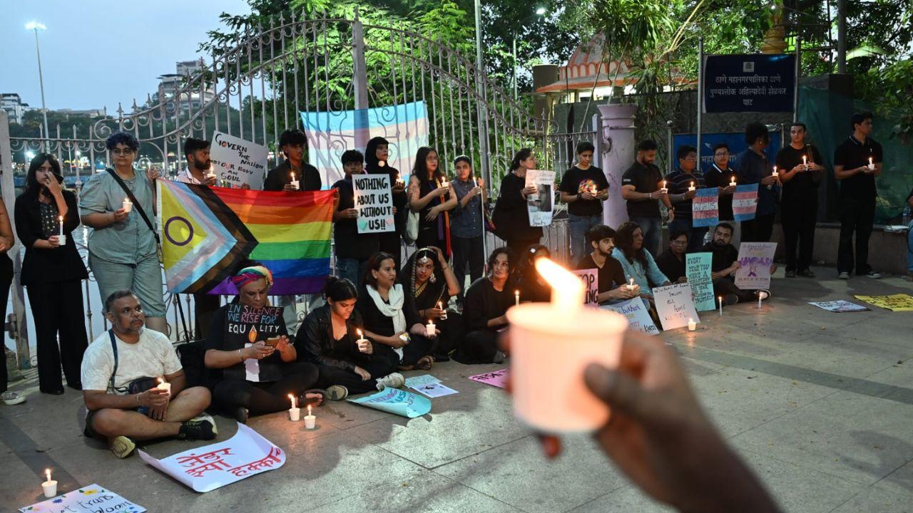 Candles flicker as protesters highlight how the proposed law could replace self-identification with a medical verification process