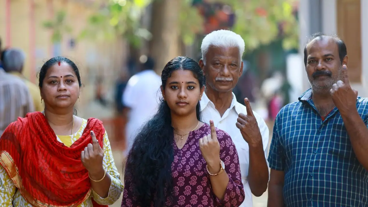 Voters show their ink-marked fingers after casting their votes, at a polling station. Pic/PTI