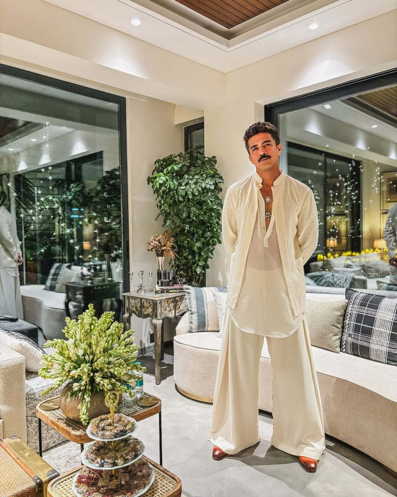 &nbsp;The actor accessorises his look with a statement pendant neckpiece and wraps his outfit with brown shoes.