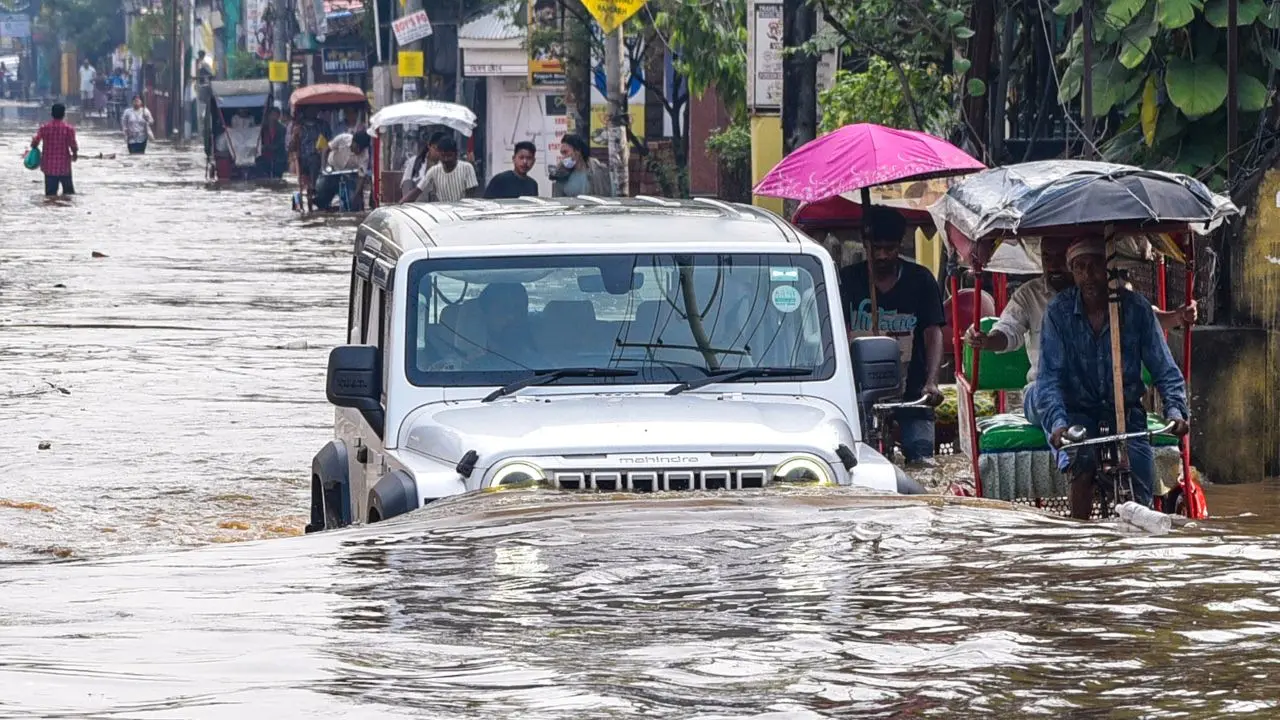 Vehicles wade through a waterlogged road triggered by heavy rainfall. Pic/PTI