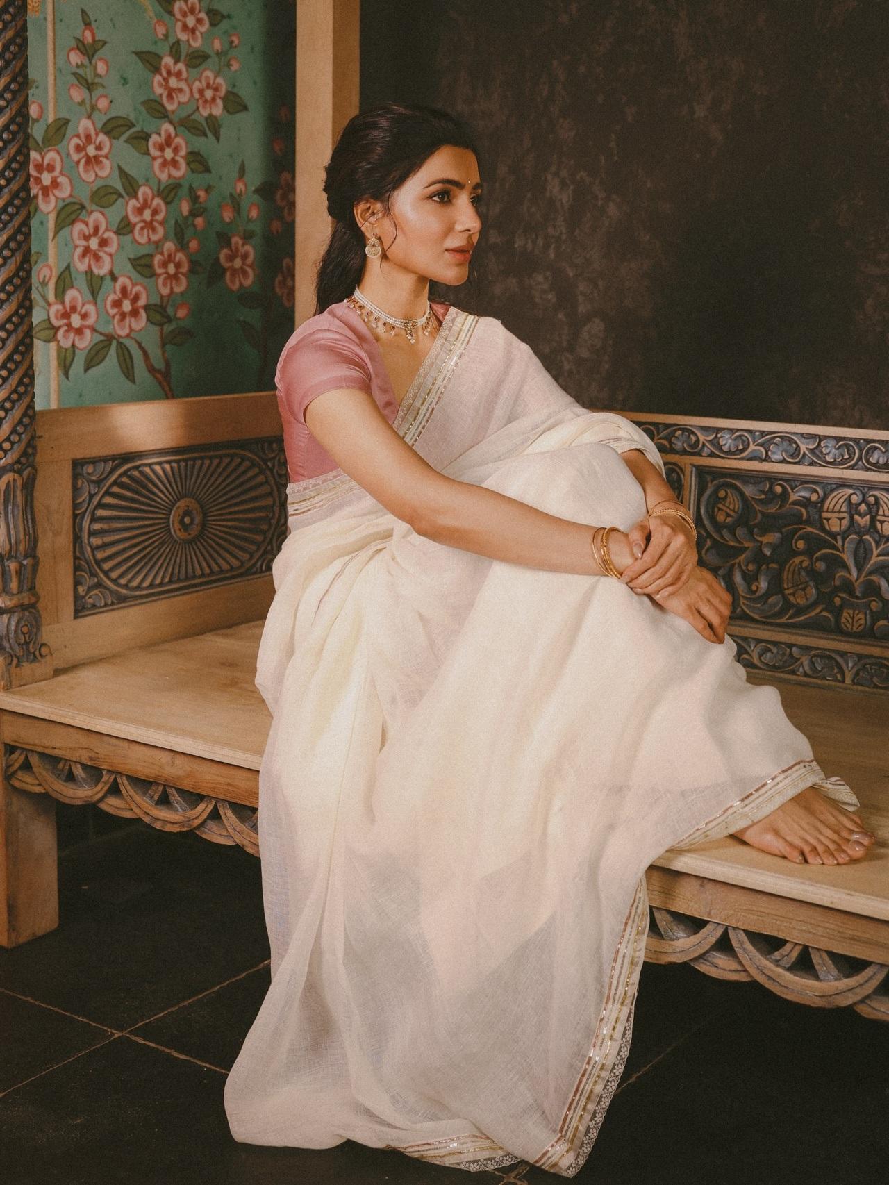 Samantha looks effortlessly graceful in this simple ivory linen saree, which features a subtle striped border. She pairs it with a contrasting dusty pink silk blouse and delicate pearl jewelry.