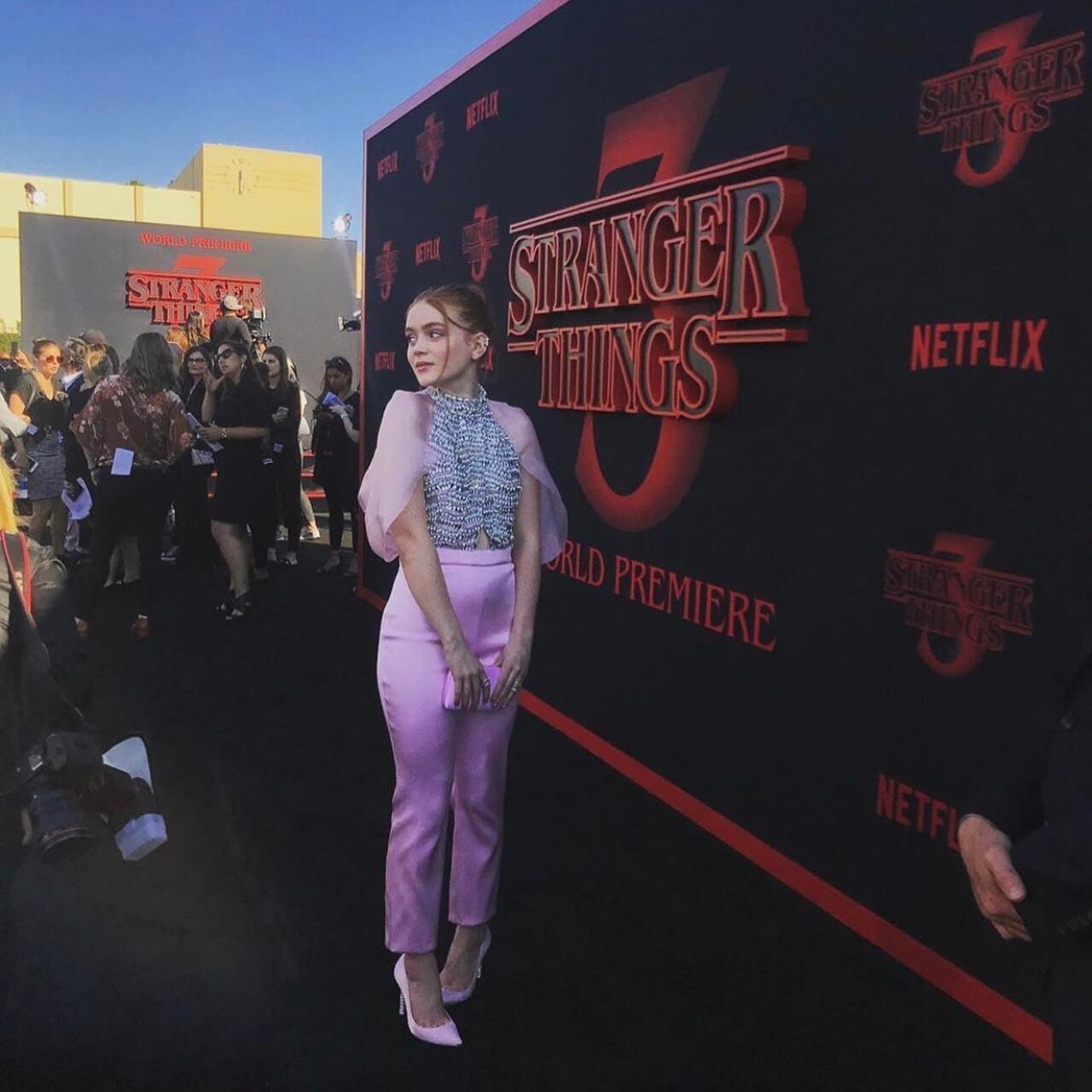 Sadie Sink captures a playful yet glamorous vibe in this lavender and silver ensemble, featuring high-waisted tailored trousers paired with a shimmering crystal-embellished crop top.&nbsp;