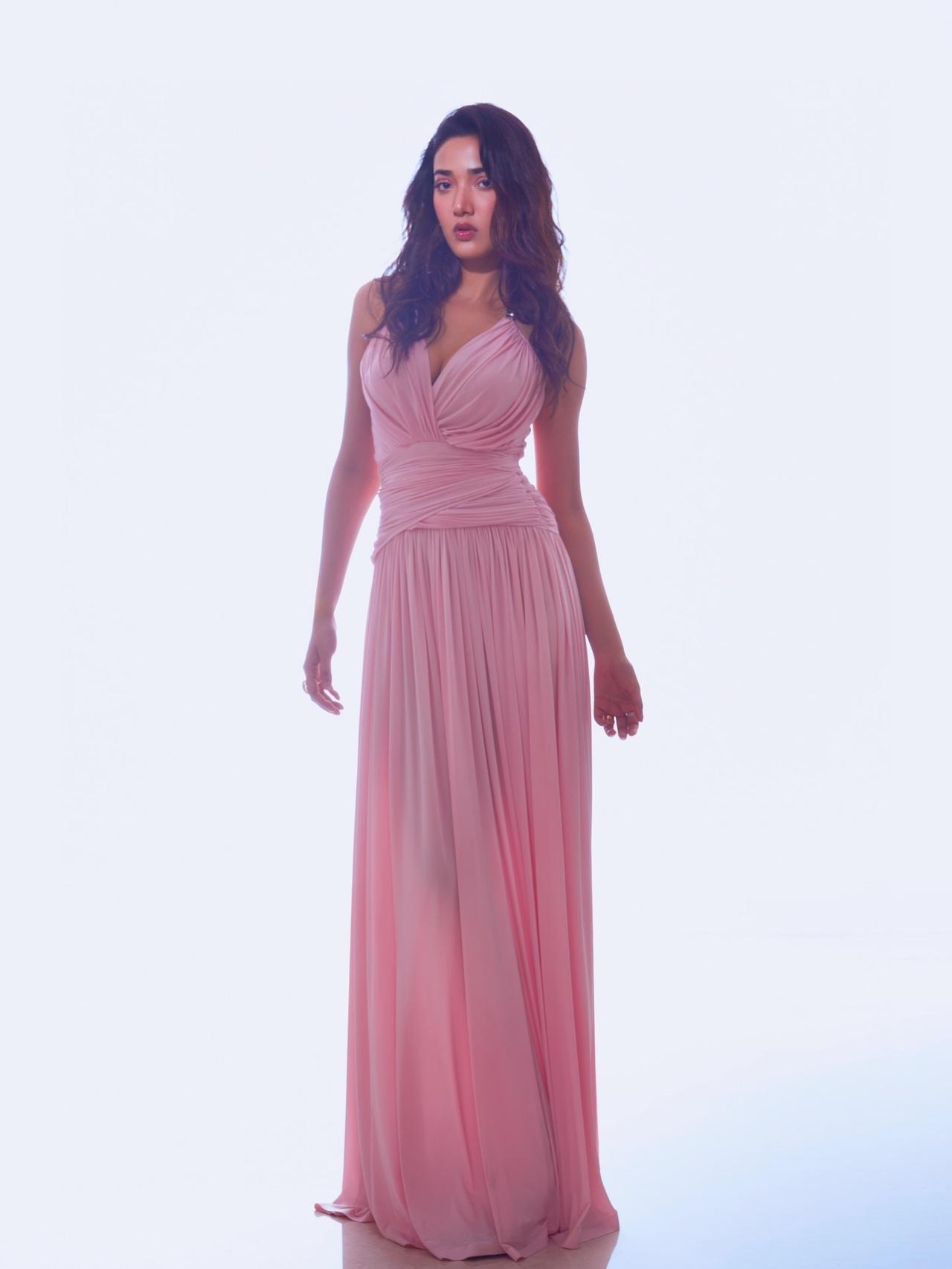 She keeps the styling understated yet refined, pairing the look with simple pearl-style earrings and a cocktail ring, allowing the soft hue of the gown to take center stage.