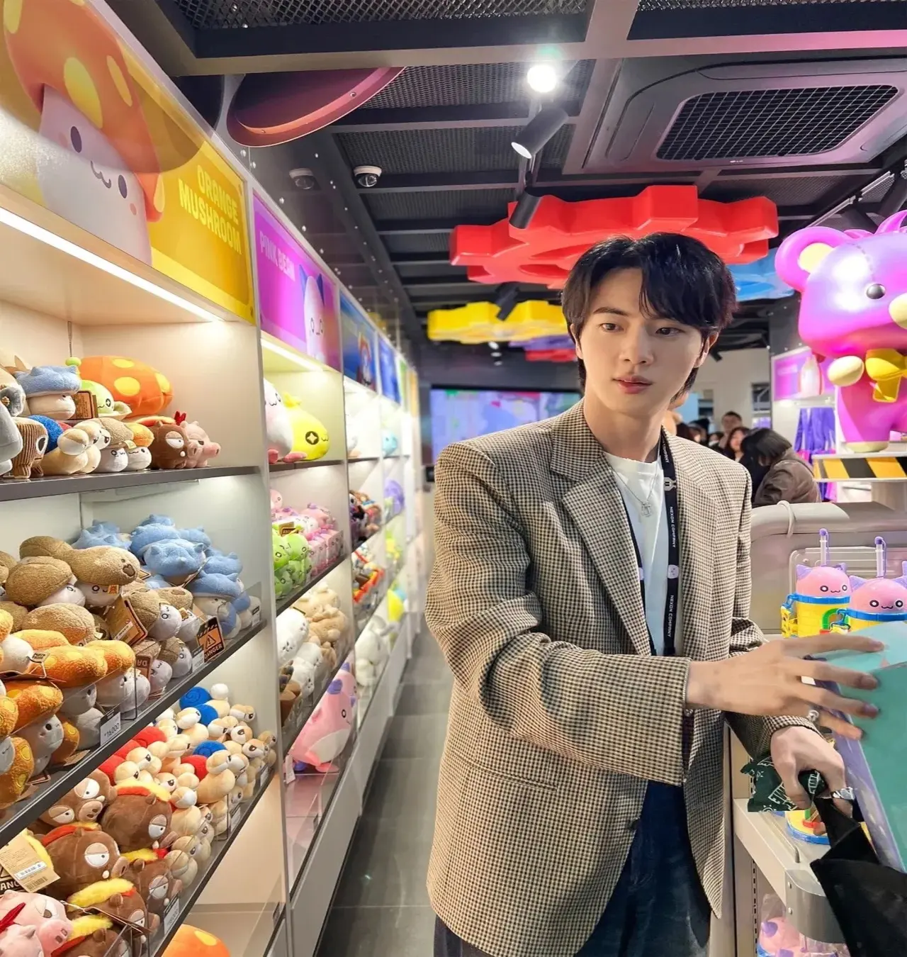 Here, he is in a shop surrounded by rows and rows of stuffed toys and merchandise. Spoiled for choice, he seems undecided about which one to pick