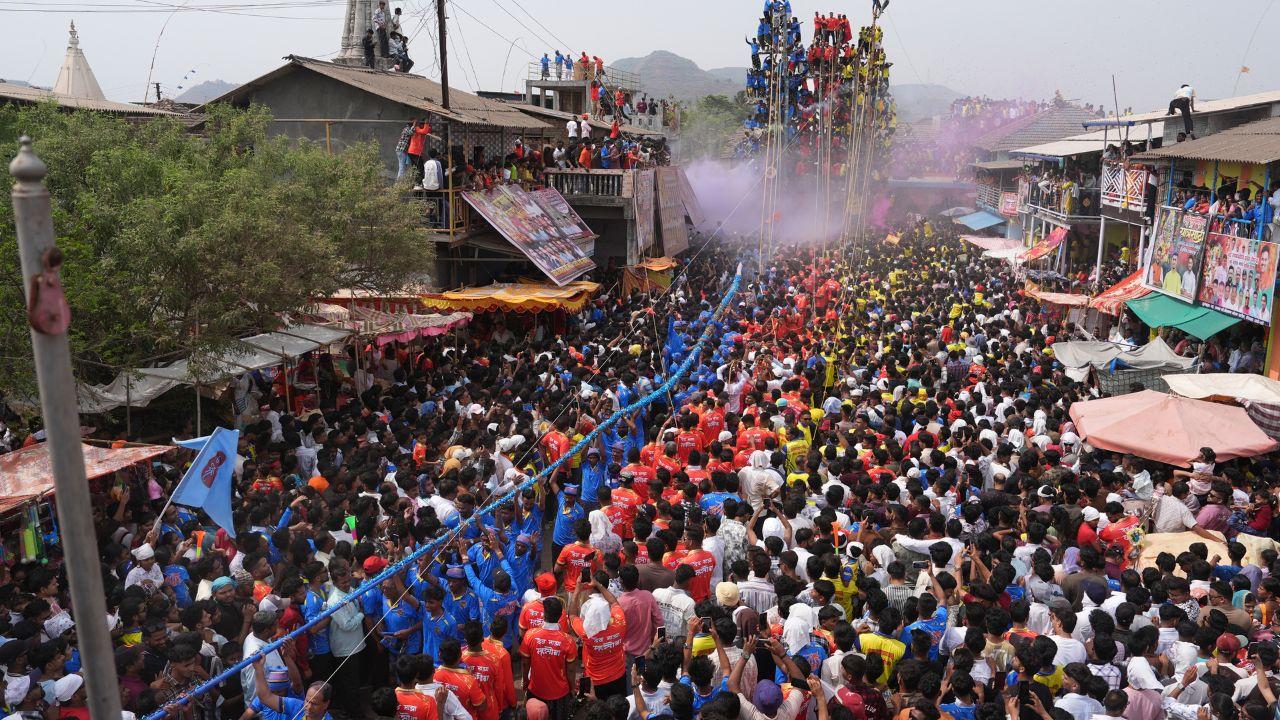The atmosphere is vibrant, with locals dressed in traditional attire participating with devotion and enthusiasm