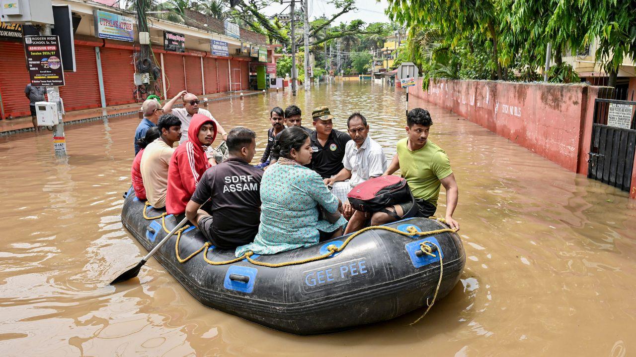 State Disaster Response Force (SDRF) personnel rescue people on an inflatable boat after heavy rainfall caused waterlogging, in Guwahati