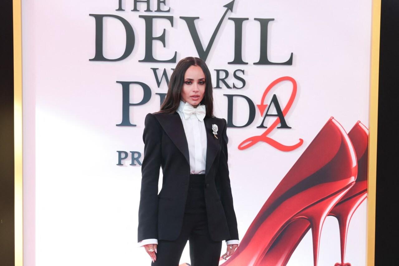Sofia Carson looks effortlessly cool at the NYC premiere in a modern, feminine take on the classic tuxedo by Francesco Scognamiglio. Her look features a tailored black blazer with wide lapels and matching slim-fit trousers, styled with a crisp white shirt and a perfectly tied white bow tie.