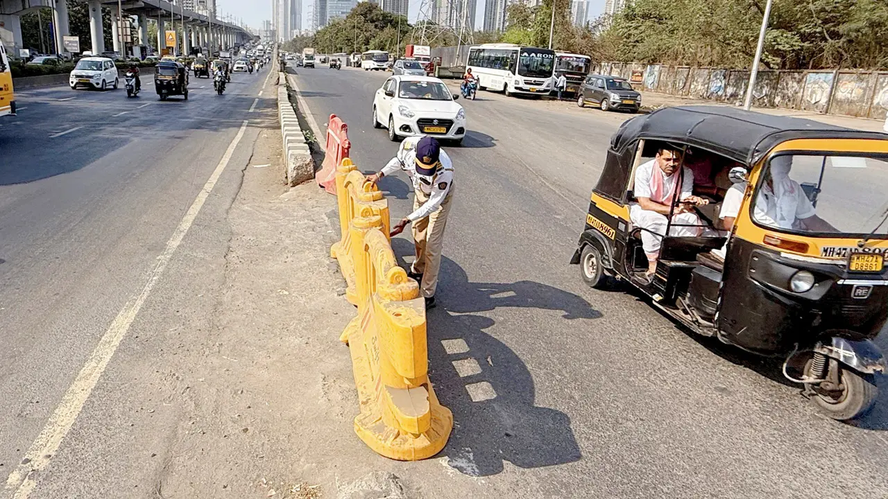 Temporary fix: A traffic constable installs plastic barricades to block the gap on Monday