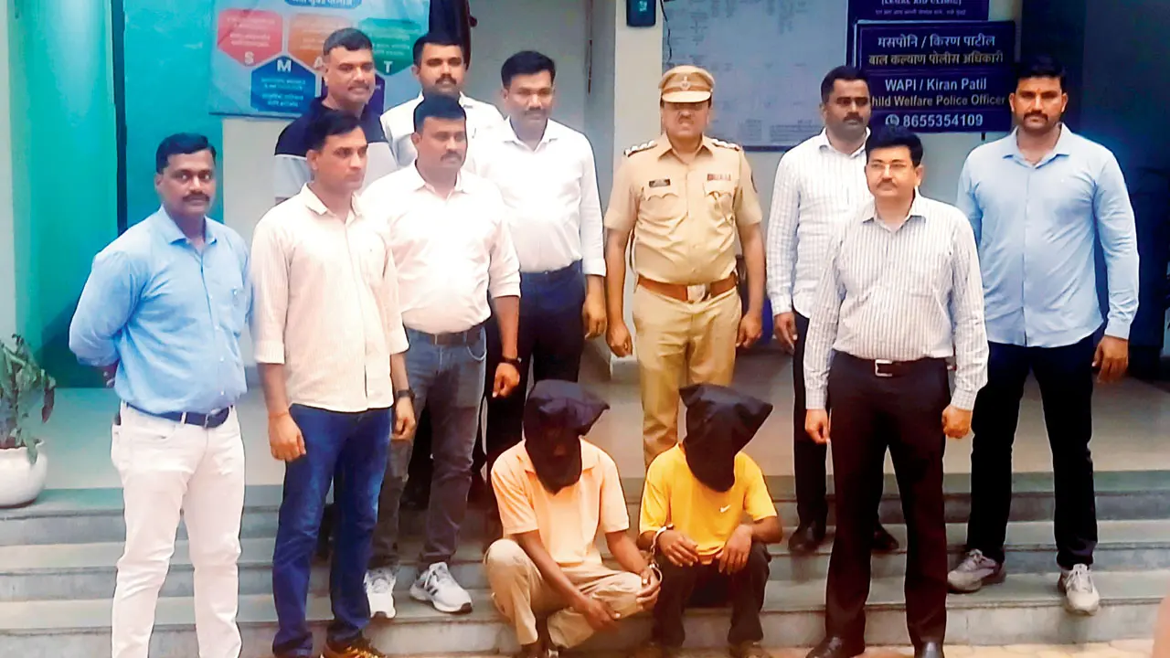 CBD Belapur police with the arrested duo, seen kneeling after being nabbed in the Akash Rathod murder case. Pic/Abhitash Singh 