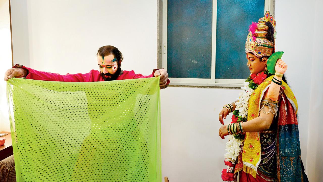 In a quiet moment of scrutiny, an artiste checks his costume, ensuring every element aligns with the authenticity of the performance