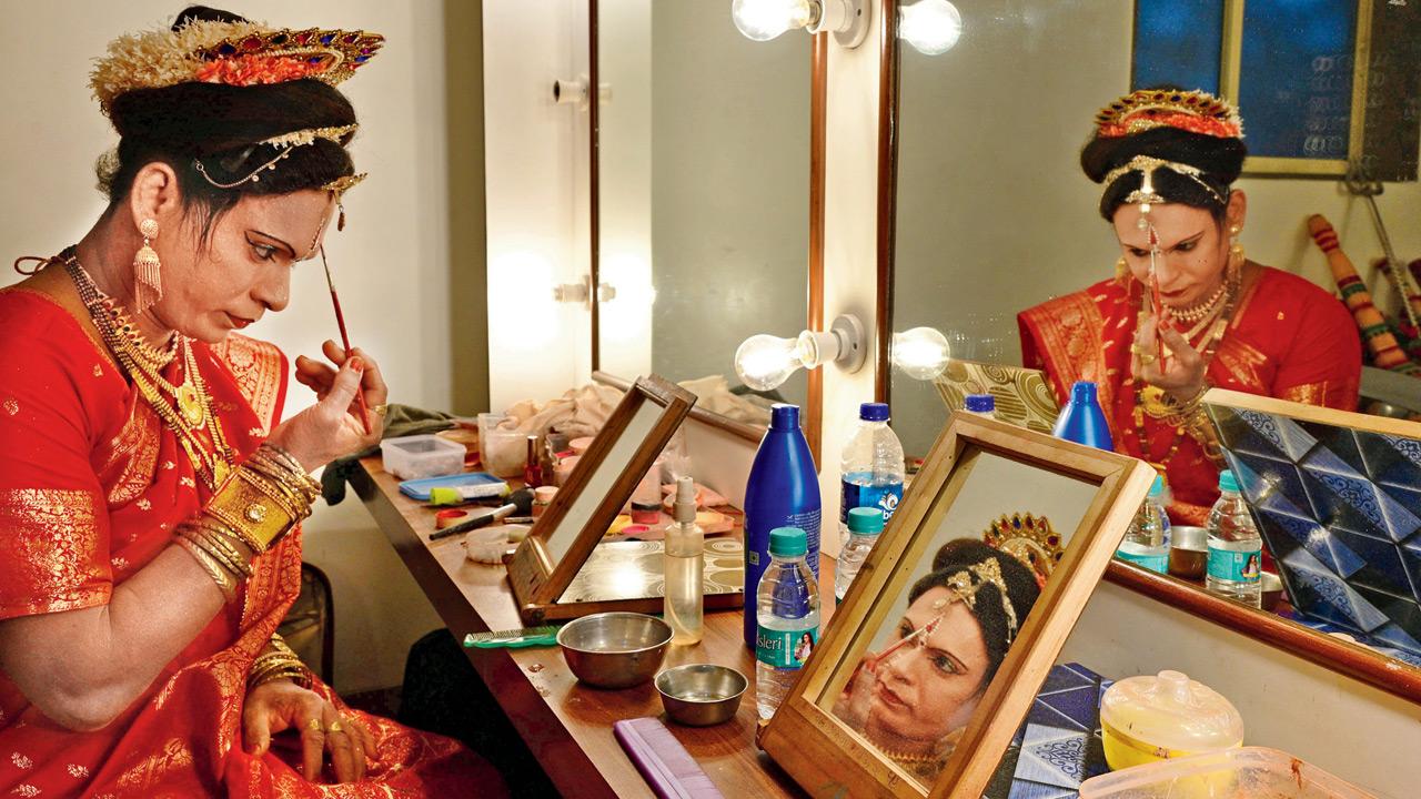 Precision meets tradition as a performer adds the finishing touches to his make-up ahead of the live act