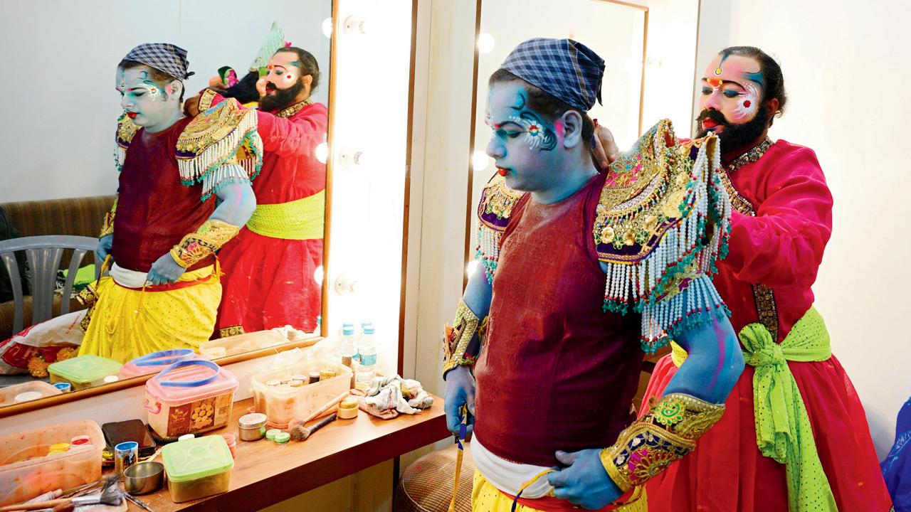 Team spirit takes centre stage as one actor assists another with costume preparations before stepping into the spotlight