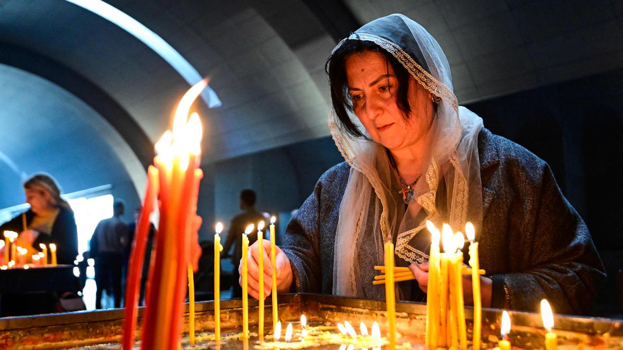 A female devotee of the Armenian Apostolic Church light candles as she attends Easter service conducted by Supreme Patriarch and head of the Catholicos of All Armenians Garegin II (Karekin II) at the Church of Holy Etchmiadzin