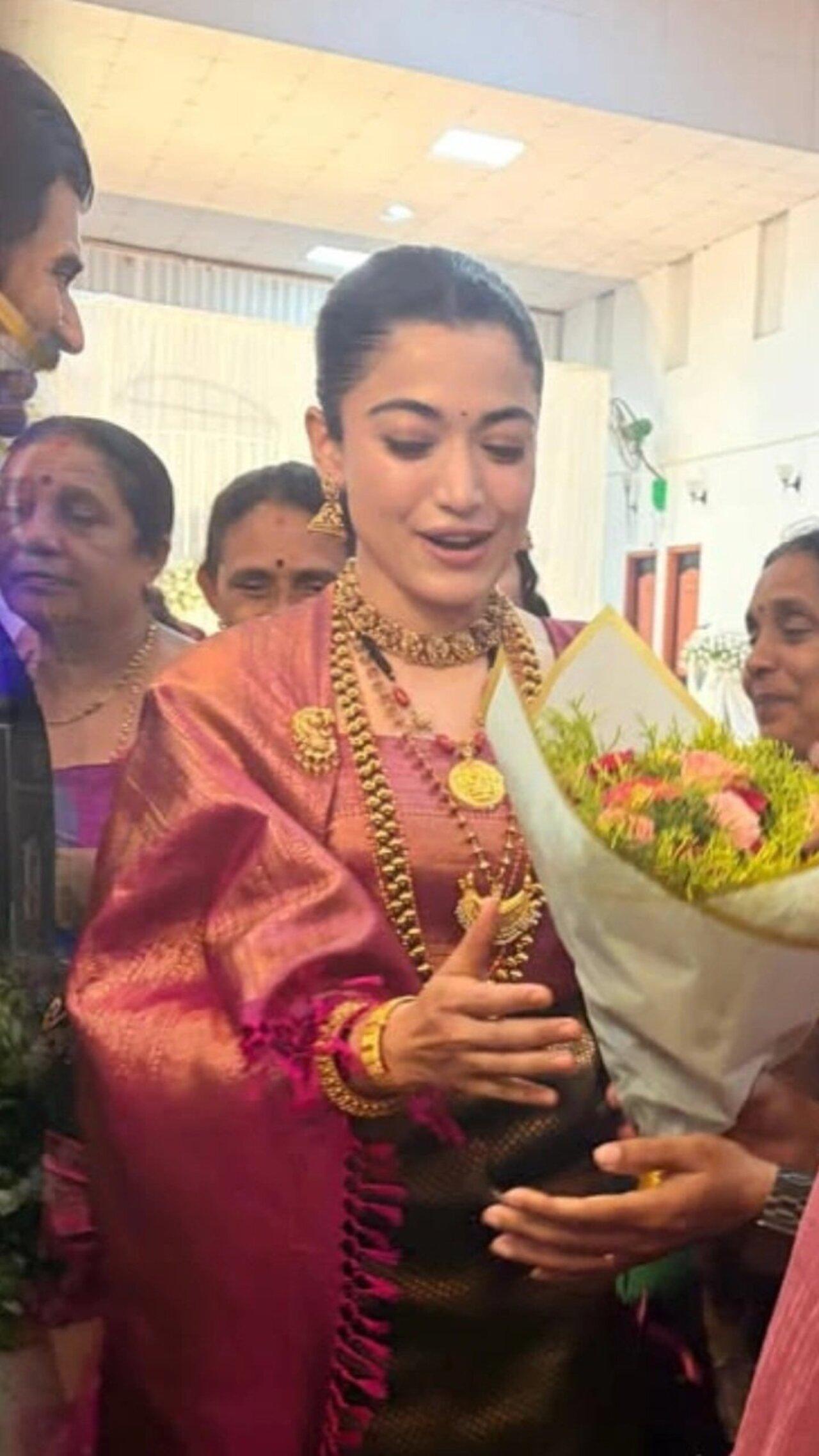 <p>Rashmika was seen dressed in traditional Coorgi attire at the reception. In this picture, she seems overwhelmed as she receives flowers from the guests.</p> <p>Rashmika was seen dressed in traditional Coorgi attire at the reception. In this picture, she seems overwhelmed as she receives flowers from the guests.</p>