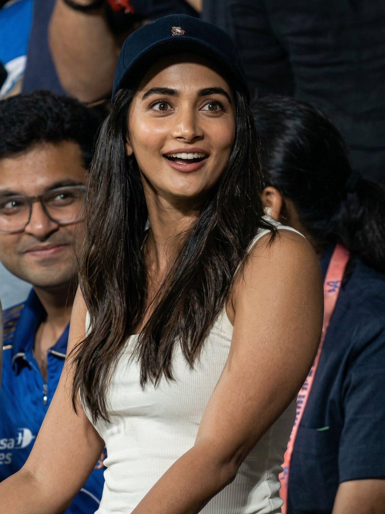 Pooja Hegde was seen enjoying the game dressed in a white tank top and denims